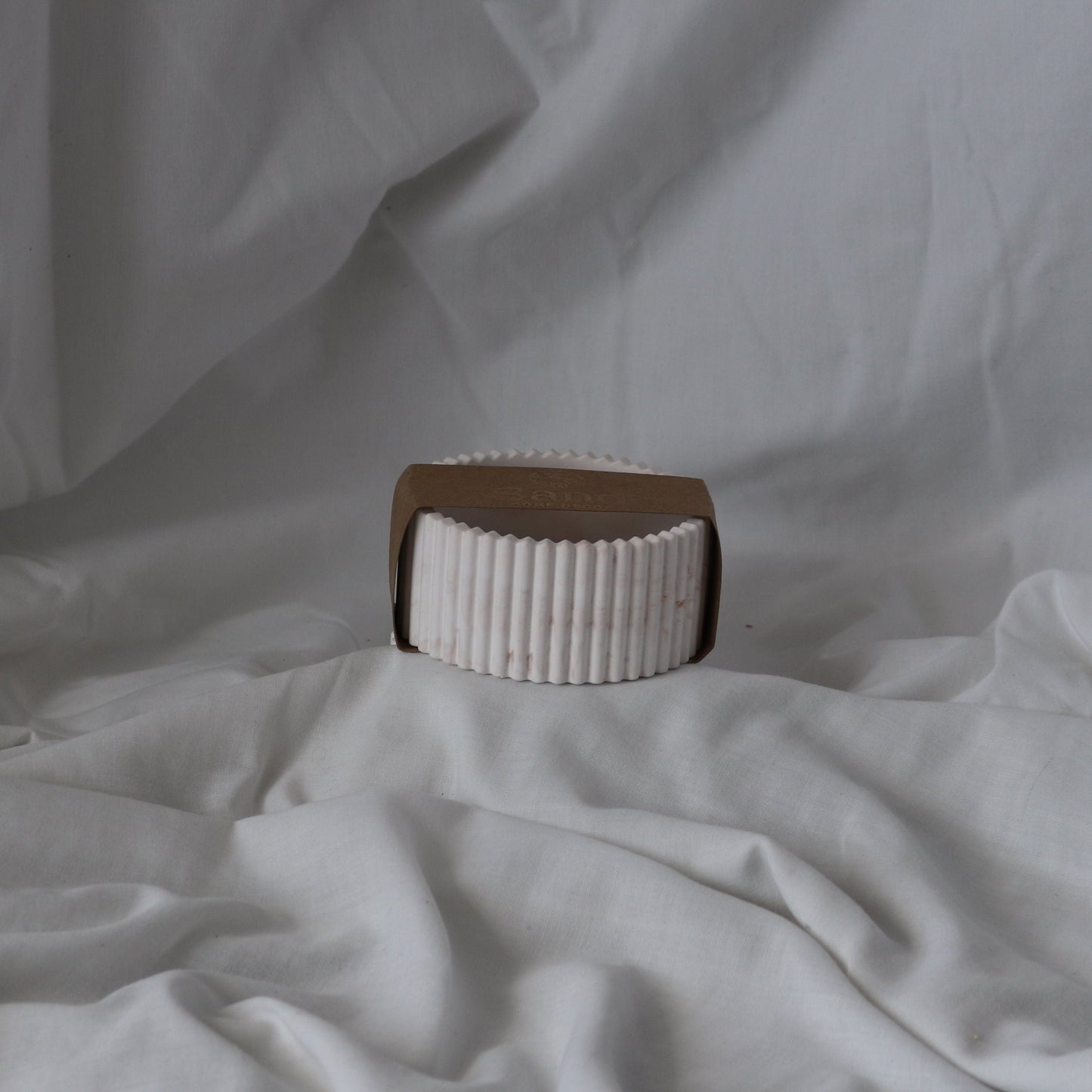 Handmade ribbed trinket dish with branded kraft paper label.