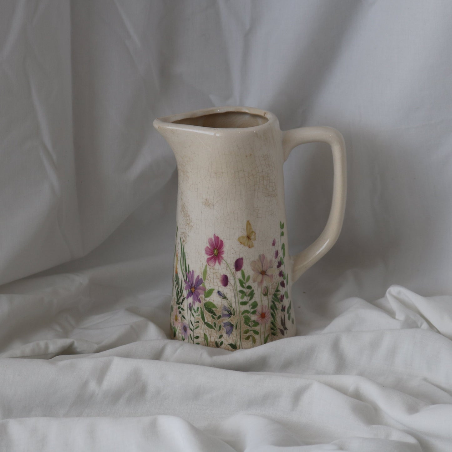 Gorgeous ceramic jug with a handmade/vintage look with flowers and butterflies on the bottom half of the jug/vase.