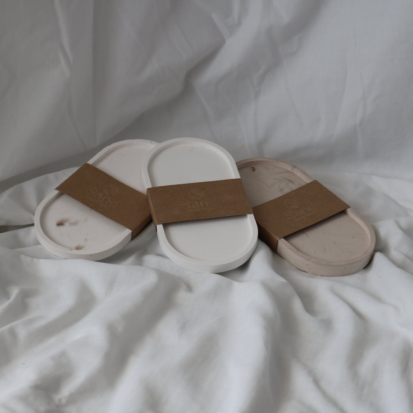 Three handmade eco resin trinket trays wrapped in branded 'Sand Home Decor' brown kraft paper labels.