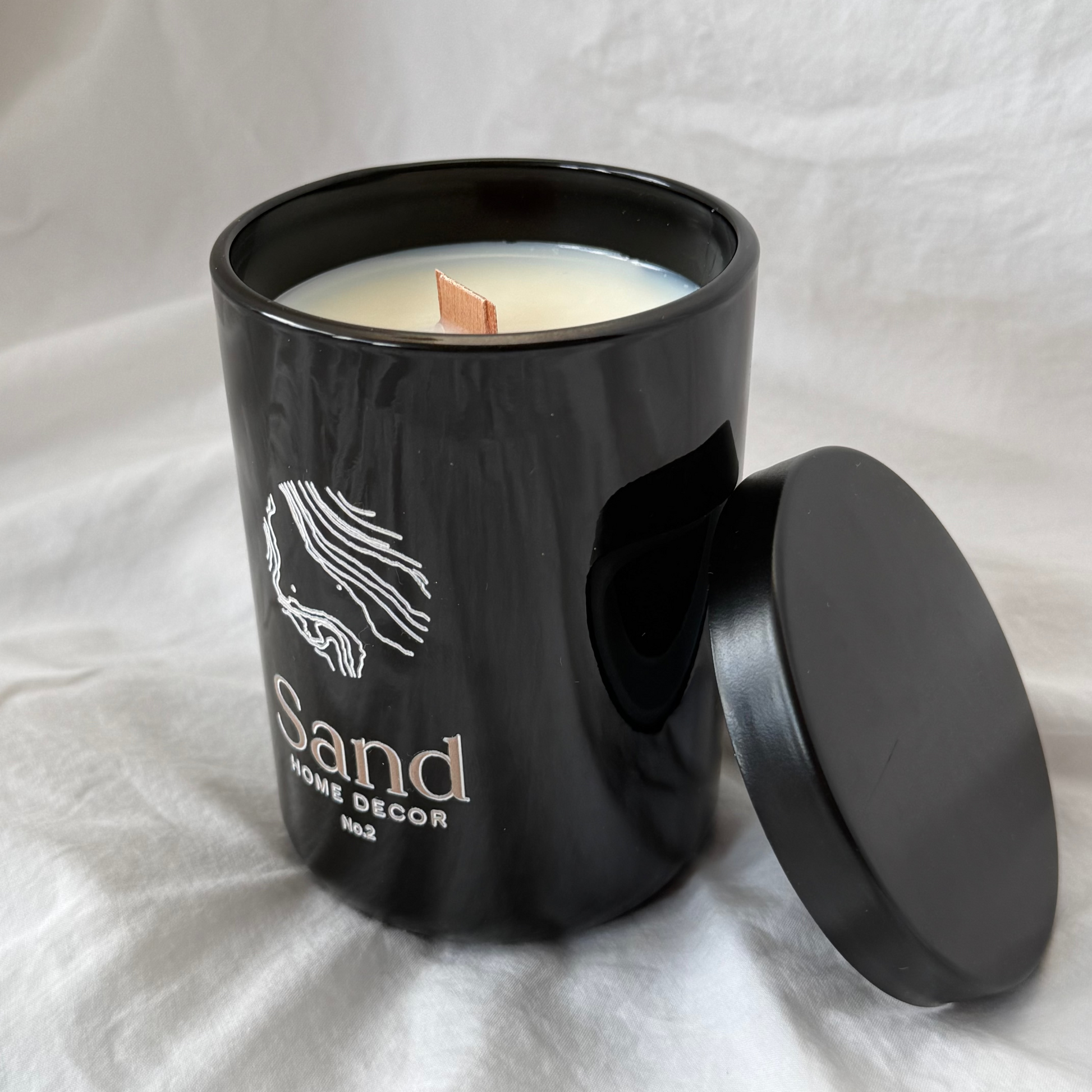single soy candle in gloss black vessel with metal lid filled with Carmel and vanilla scent and wooden wick 