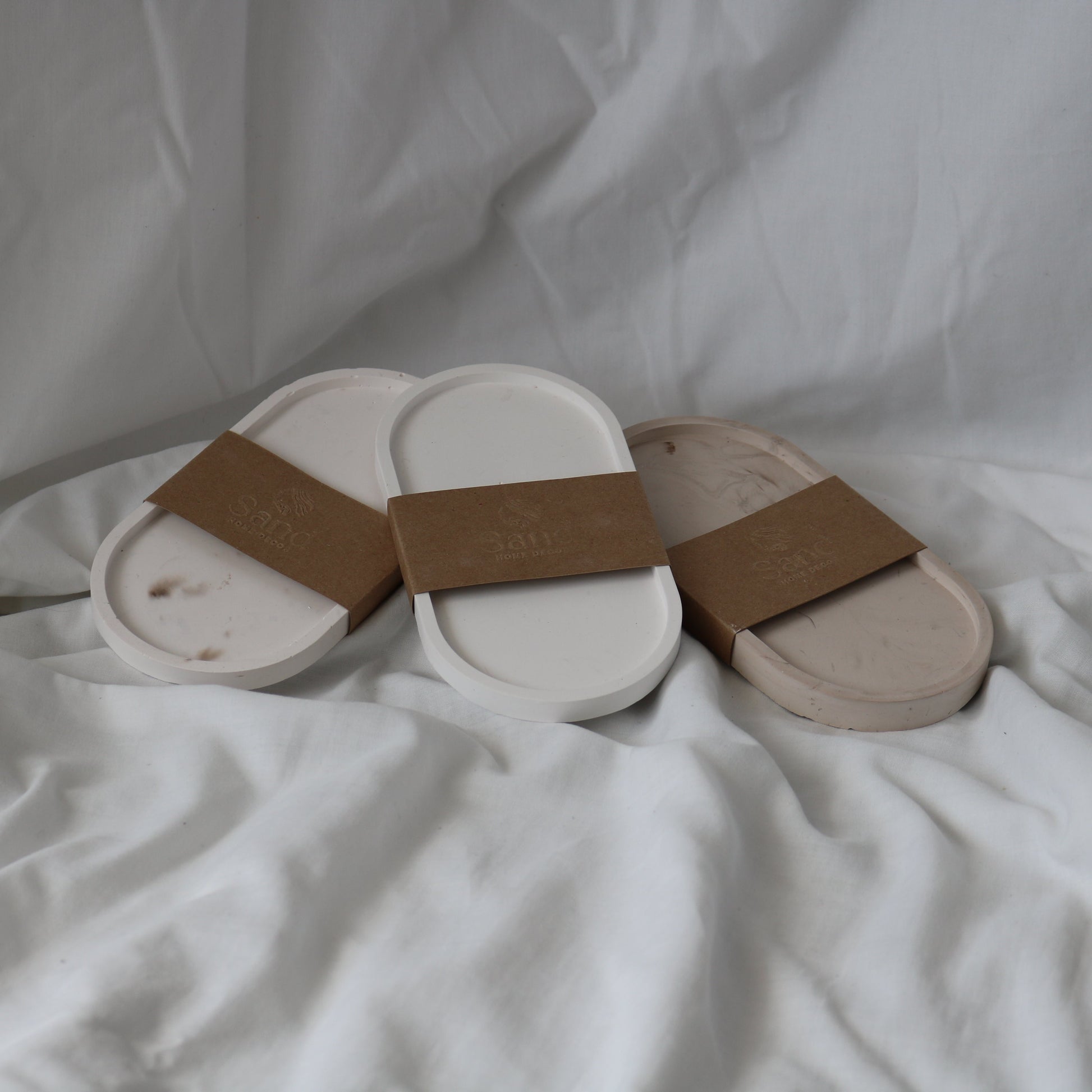 Three handmade  eco resin trinket trays wrapped in  branded 'Sand Home Decor' brown kraft paper labels. 