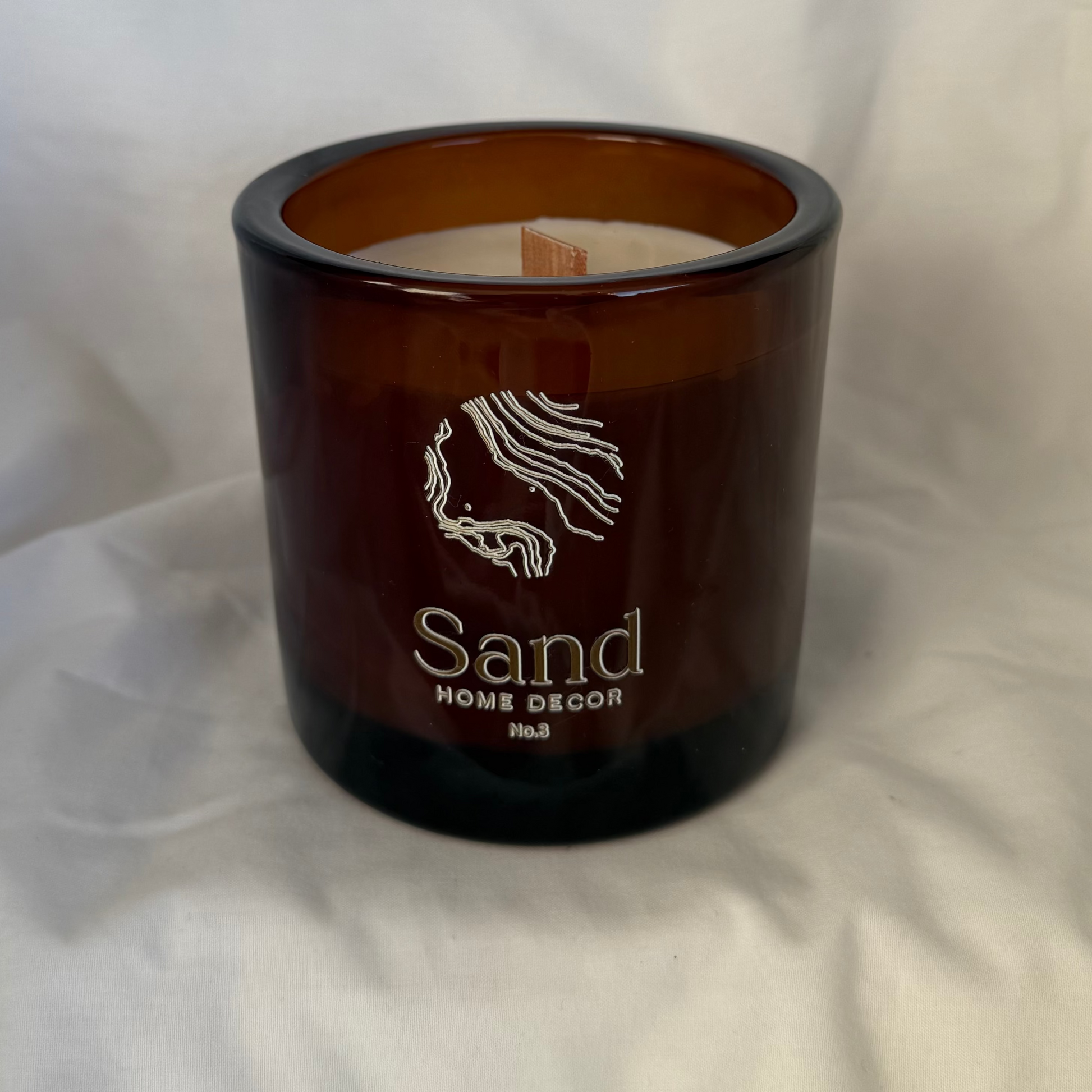 handmade soy candle with white backdrop and wooden wick 