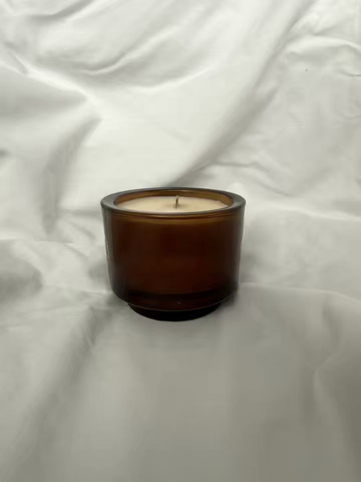 Video of handmade luxury candle turning to show logo and name. soy wax in a glass jar with a wooden wick 